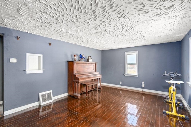 miscellaneous room featuring hardwood / wood-style floors, visible vents, and baseboards