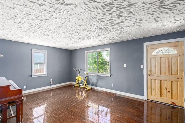 entrance foyer with a textured ceiling, baseboards, and hardwood / wood-style flooring