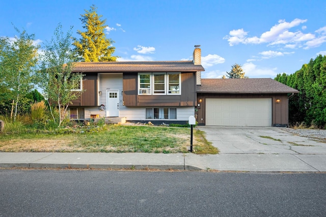 split foyer home featuring a front lawn and a garage