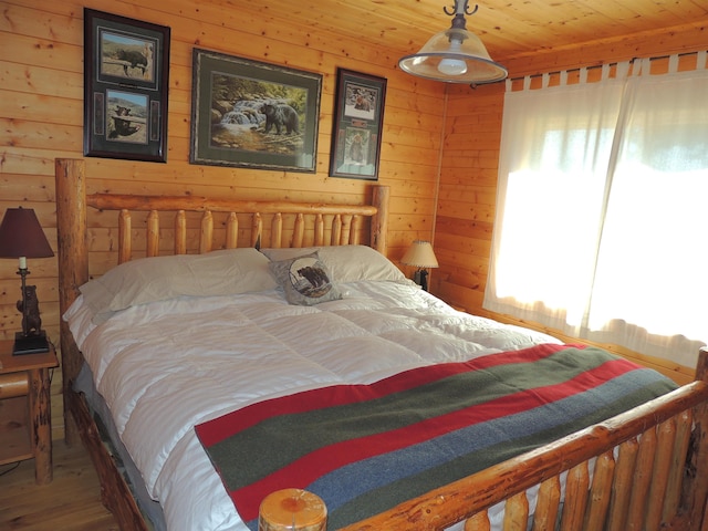 bedroom with hardwood / wood-style flooring, wood walls, and wooden ceiling