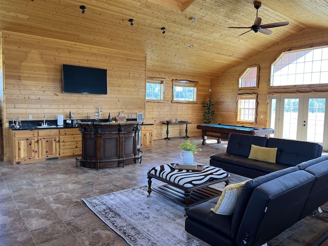 living room with wood ceiling, indoor wet bar, high vaulted ceiling, wood walls, and pool table