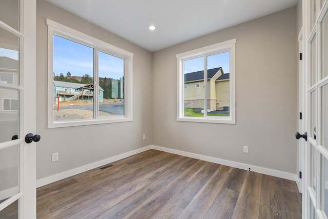 spare room with dark wood-type flooring and french doors