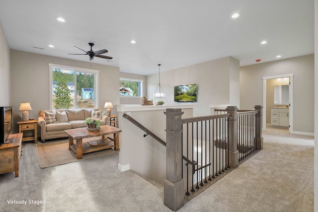 stairs with carpet floors and ceiling fan