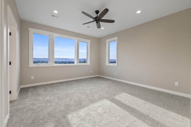 unfurnished room featuring light carpet and ceiling fan