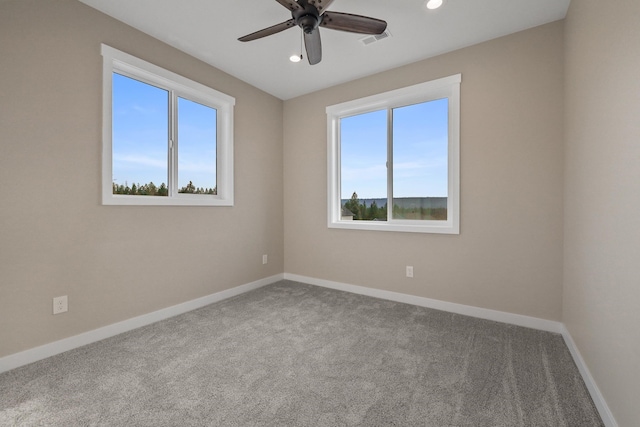 carpeted spare room with a healthy amount of sunlight and ceiling fan