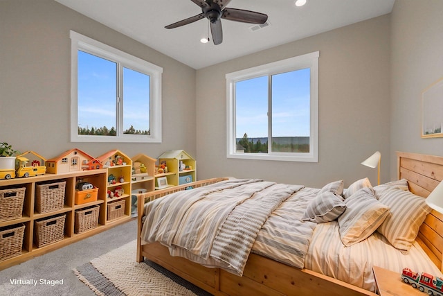 carpeted bedroom featuring ceiling fan and multiple windows