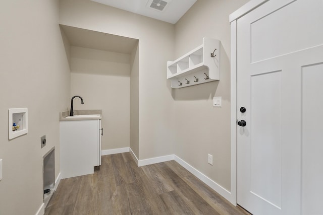 laundry area with cabinets, hardwood / wood-style flooring, hookup for a washing machine, hookup for an electric dryer, and sink