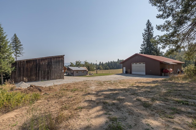 1114 Stohr Rd, Newport, WA 99156 - view of yard featuring an outdoor structure, a detached garage, dirt driveway, and a pole building