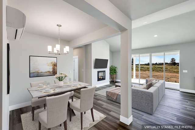 dining space featuring a chandelier, a wall unit AC, and dark hardwood / wood-style floors