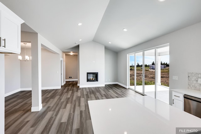 5871 S Sherri Lea Rd, Spokane, WA 99224 - unfurnished living room with baseboards, wood finished floors, a glass covered fireplace, and vaulted ceiling
