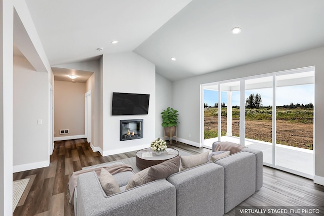 living area featuring wood finished floors, baseboards, lofted ceiling, recessed lighting, and a glass covered fireplace