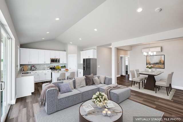 5871 S Sherri Lea Rd, Spokane, WA 99224 - living room featuring baseboards, dark wood-style flooring, vaulted ceiling, a wall mounted air conditioner, and a notable chandelier