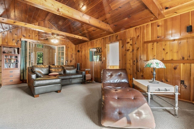 carpeted living room with a wealth of natural light, ceiling fan, and wooden walls