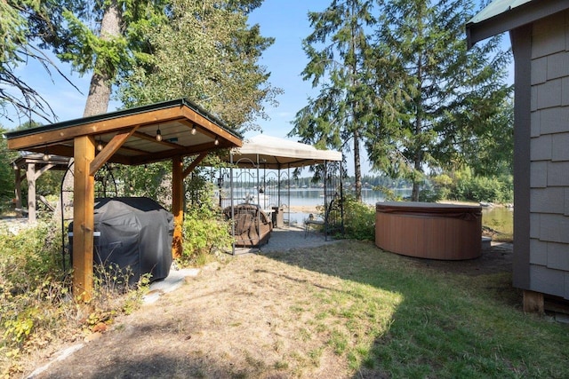 view of yard with a water view and a hot tub