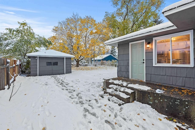 yard layered in snow with an outbuilding