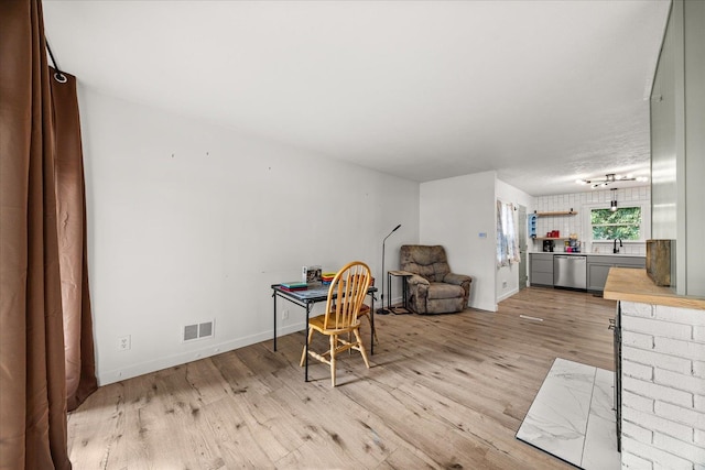 home office featuring light hardwood / wood-style flooring and sink