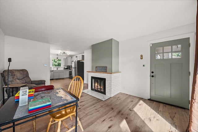 dining room featuring light hardwood / wood-style floors and a brick fireplace