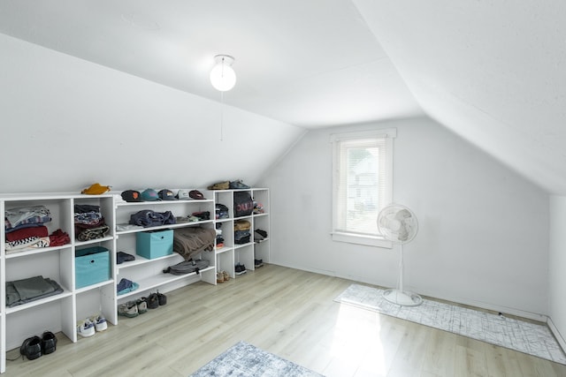 additional living space featuring light wood-type flooring and vaulted ceiling