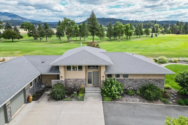 prairie-style home featuring a mountain view and a front lawn