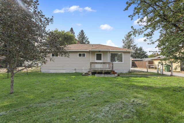 back of property featuring a lawn and a wooden deck