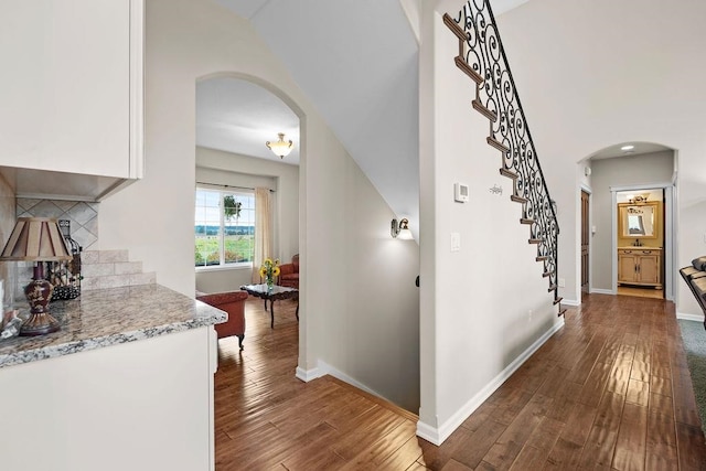 interior space featuring lofted ceiling, dark hardwood / wood-style floors, and sink