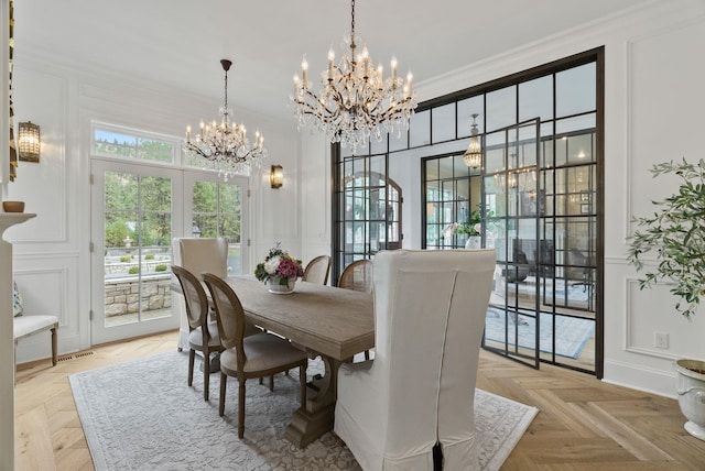 dining space featuring crown molding, light parquet floors, a notable chandelier, and french doors