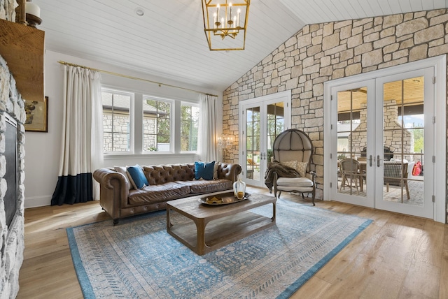 living room featuring light wood-type flooring, french doors, and lofted ceiling