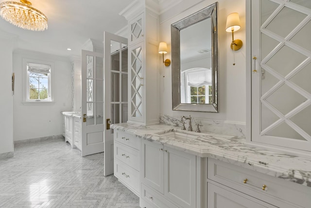 bathroom with ornamental molding, vanity, parquet flooring, and a notable chandelier