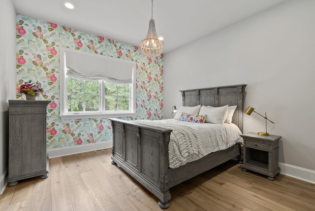 bedroom with light wood-type flooring and a chandelier