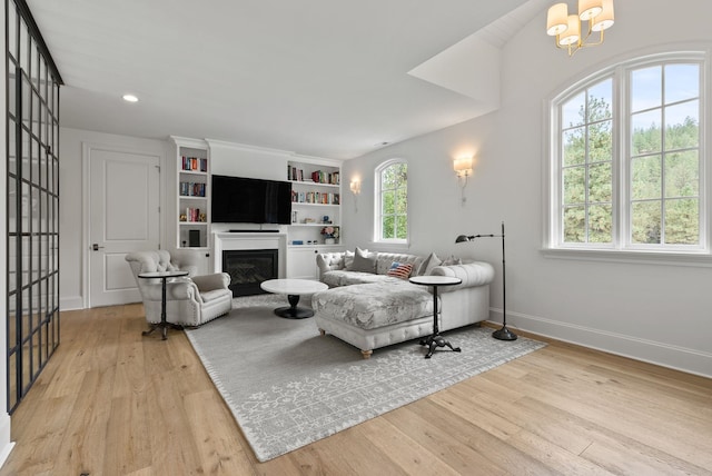 living room with light wood-type flooring and an inviting chandelier