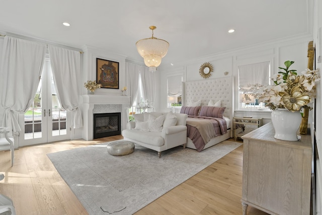 bedroom with french doors, light hardwood / wood-style floors, access to exterior, and ornamental molding