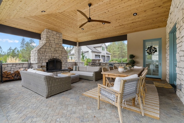 view of patio / terrace featuring area for grilling, ceiling fan, and an outdoor living space with a fireplace