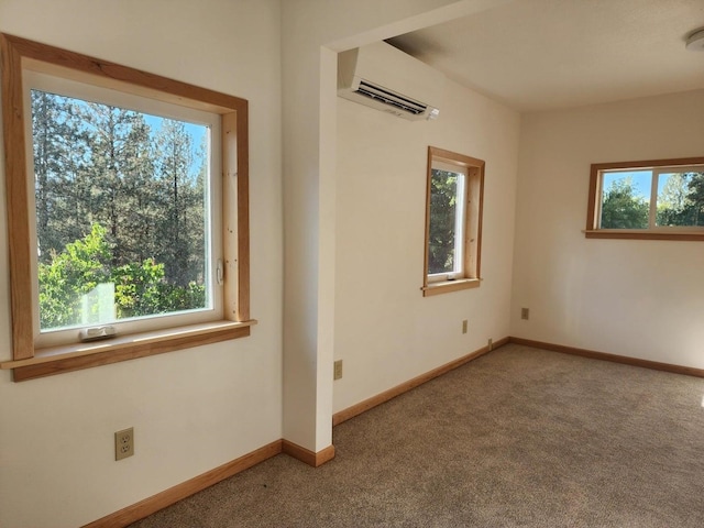 carpeted empty room featuring an AC wall unit and a wealth of natural light