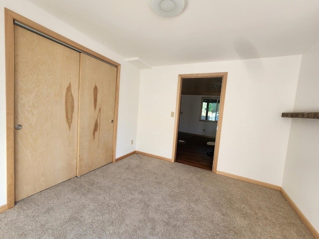 unfurnished bedroom with light carpet and a closet