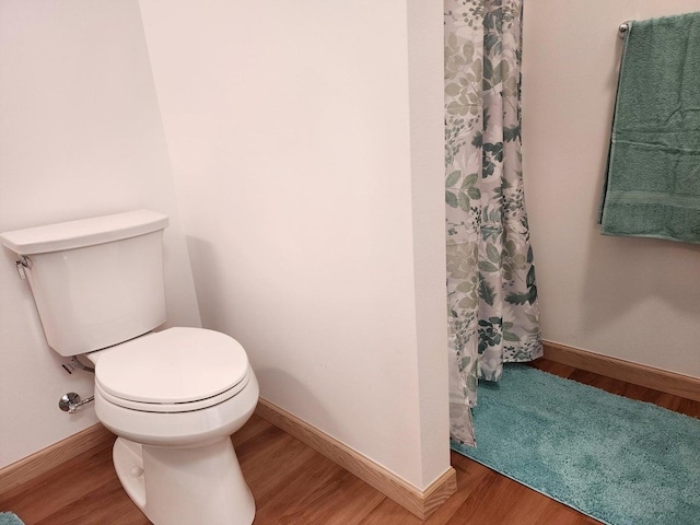 bathroom with walk in shower, hardwood / wood-style floors, and toilet