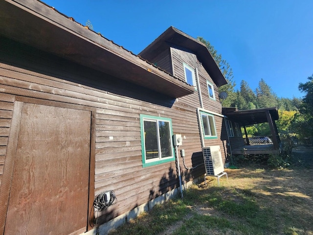 view of property exterior featuring a lawn and cooling unit