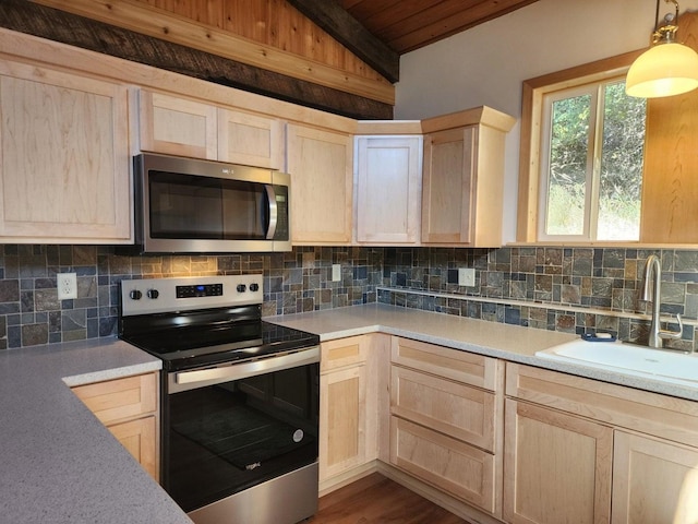 kitchen with decorative backsplash, light brown cabinetry, and stainless steel appliances