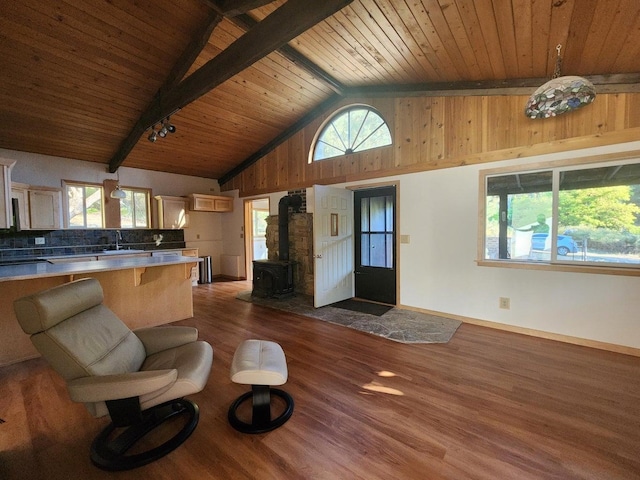 living room featuring wood ceiling, dark wood-type flooring, high vaulted ceiling, beamed ceiling, and a wood stove