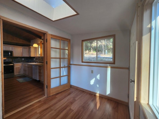 interior space featuring sink, lofted ceiling, and hardwood / wood-style floors