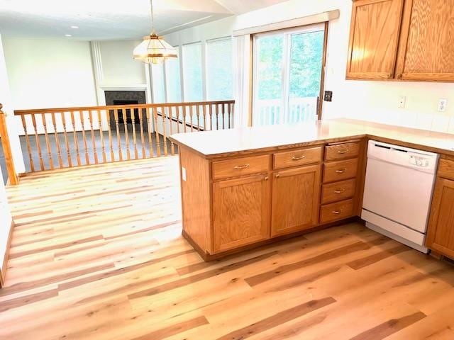 kitchen featuring light hardwood / wood-style floors, dishwasher, kitchen peninsula, and decorative light fixtures