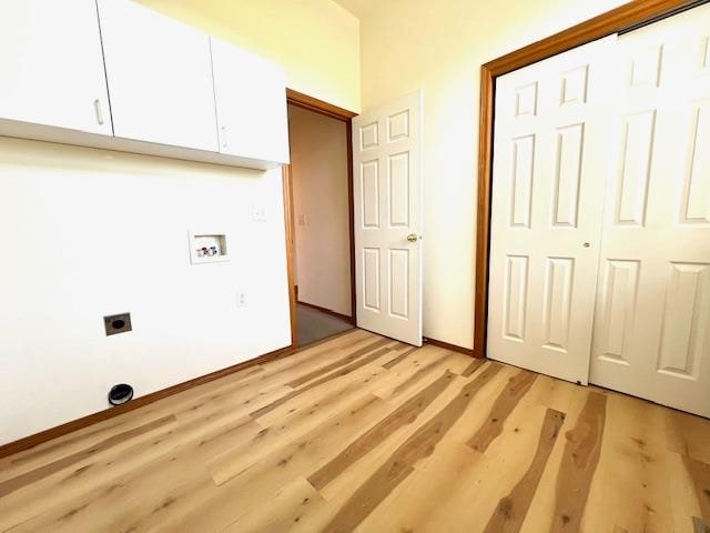 clothes washing area with cabinets, hookup for an electric dryer, light hardwood / wood-style flooring, and hookup for a washing machine