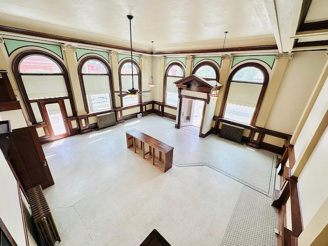 interior space featuring ceiling fan, beamed ceiling, a wealth of natural light, and ornamental molding