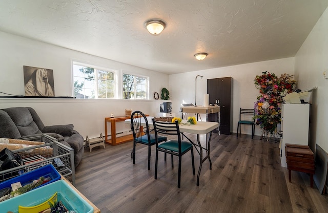 dining area featuring a textured ceiling and dark wood-type flooring