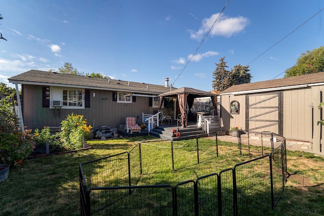 back of property featuring a lawn, a storage shed, a gazebo, and a deck