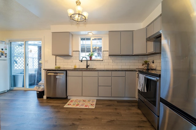 kitchen with appliances with stainless steel finishes, gray cabinets, ventilation hood, dark hardwood / wood-style floors, and sink