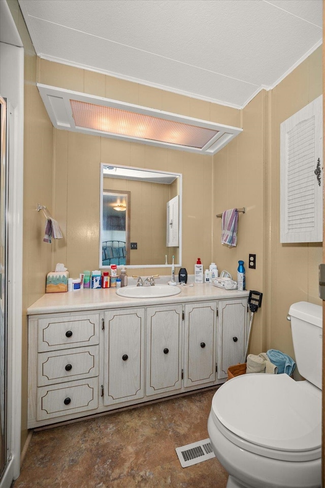 bathroom featuring crown molding, vanity, and toilet