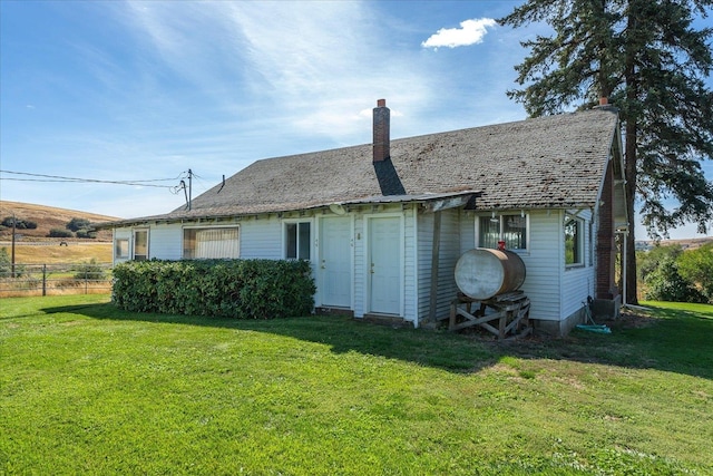 rear view of property with a yard