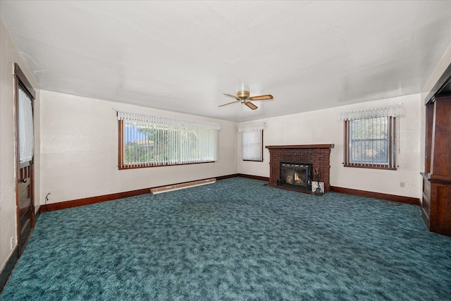 unfurnished living room with ceiling fan, a fireplace, plenty of natural light, and dark carpet