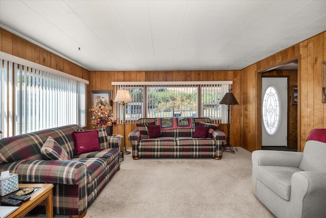 carpeted living room featuring wood walls