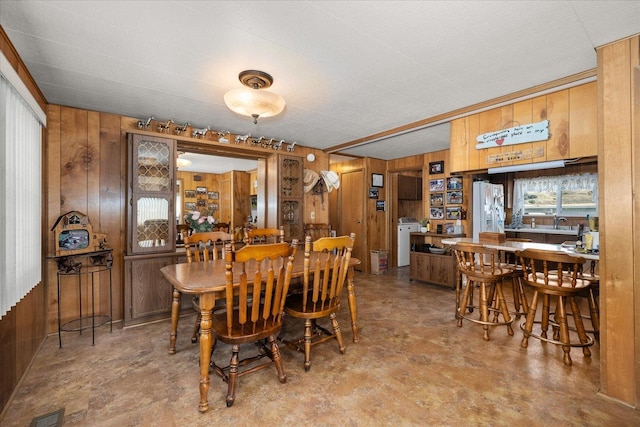 dining space featuring wooden walls and washer / clothes dryer